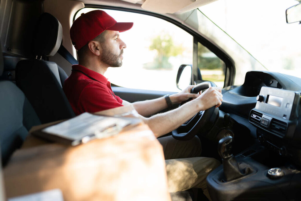 DoorDash delivery driver in red uniform behind the wheel of a van in Portland, Oregon – relevant to legal assistance after a DoorDash accident.